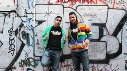 Zwei Jugendliche vor einer Mauer