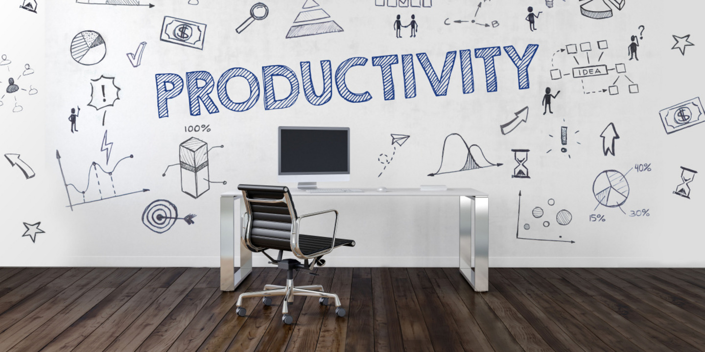 In einem Raum steht grafiitiartig das Wort Productivity. Vor der Wand steht  ein brauner Bürostuhl an einem Schreibtisch