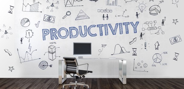 Schreibtisch und Stuhl vor einer Wand voller Buzzwords - in der Mitte steht groß "Productivity"