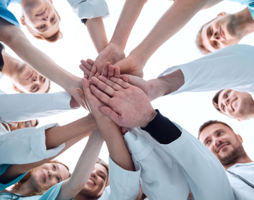 Junge Ärzte halten sich an den Händen.