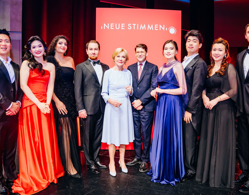 - Liz Mohn, Präsidentin des Wettbewerbs und Vorsitzende des Vorstands der Liz Mohn Stiftung, zusammen mit Alexander Neef, Vorsitzender der Jury der NEUEN STIMMEN, und den Finalist:innen des Wettbewerbs 2026.