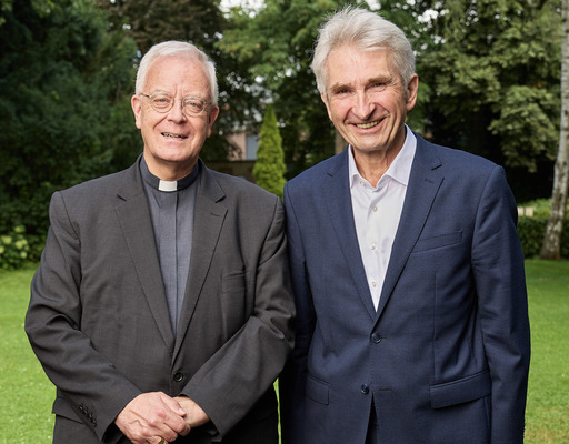 Matthias König, Weihbischof im Erzbistum Paderborn, und Andreas Pinkwart, Vorstand der Bertelsmann Stiftung, posieren am Rande des Besuchs Königs in Gütersloh für ein gemeinsames Foto.