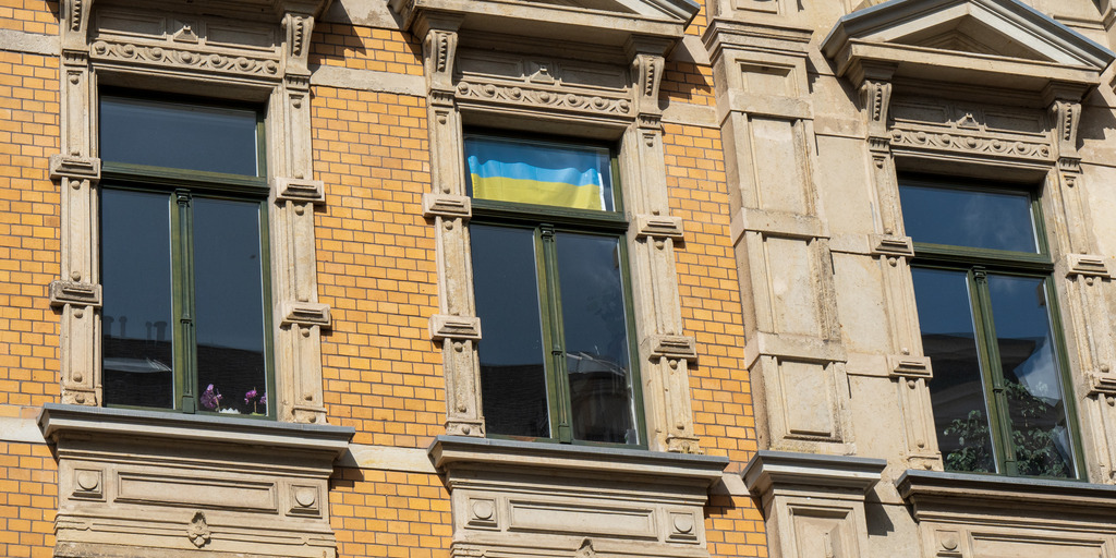 großes Wohnhaus Altbau mit Ukrianeflagge im Fenster in Leipzig