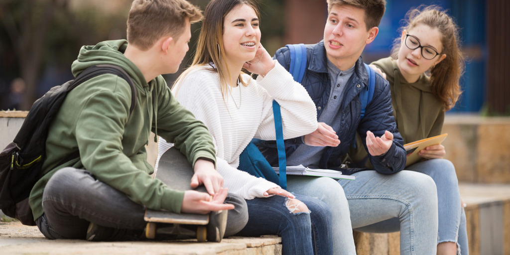 Vier Jugendliche sitzen und unterhalten sich