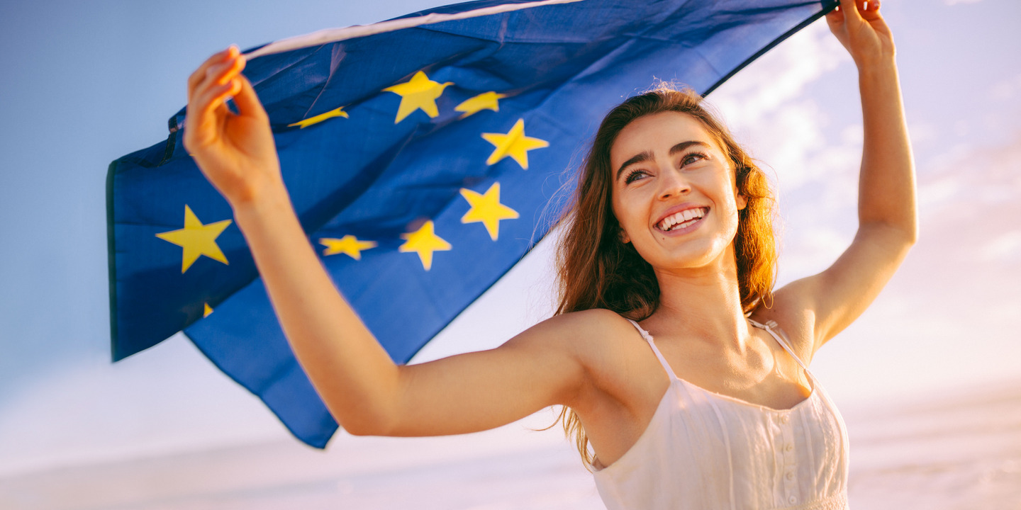 Junge Frau hält Fahne der EU