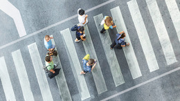 People crossing a street at a cross-walk, viewed from above.