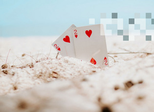 Spielkarten stecken im Sand