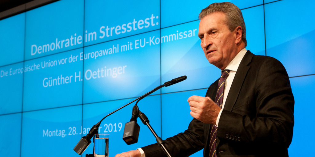 EU-Haushaltskommissar Günther Oettinger steht während seiner Europa-Rede am Rednerpult und gestikuliert, hinter ihm ist auf einer Videowand sein Name und der Name der Veranstaltung zu sehen