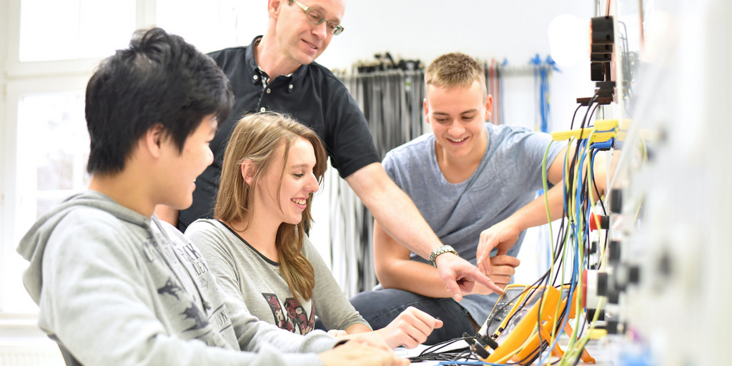 technische Berufsausbildung - Ausbilder mit jugendlichen Azubis im Unterricht an der Berufsschule