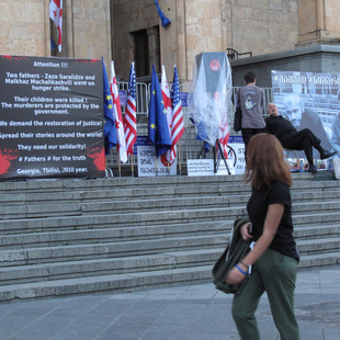 A vigil with banners and the Georgian flag.