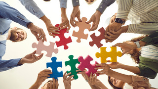 Eine Gruppe von Menschen verbindet Puzzle-Teile