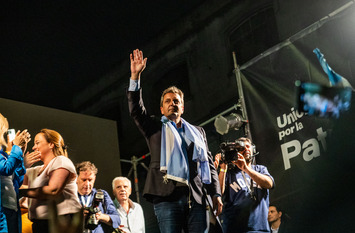 Zu sehen ist Sergio Massa, ein Präsidentschaftskandidat in Argentinien bei einer Wahlkampveranstaltung, wie er den Menschen zuwinkt.