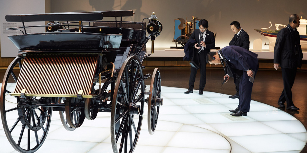 Besucher eines Automuseums bewundern den ersten Benz-Kutschenwagen