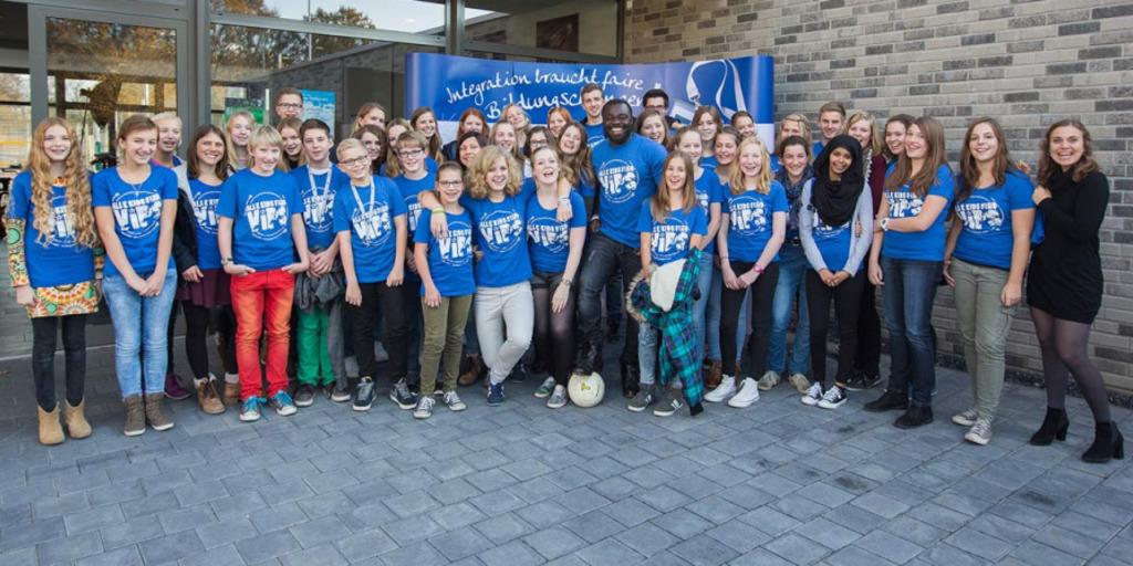 Gruppenfoto von Schalke-Profi Gerald Asamoah mit den Schülerinnen und Schülern der Courage Schülerstiftung in Münster.