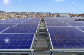 Front view of solar panels on a rooftop overlooking the Barcelona skyline